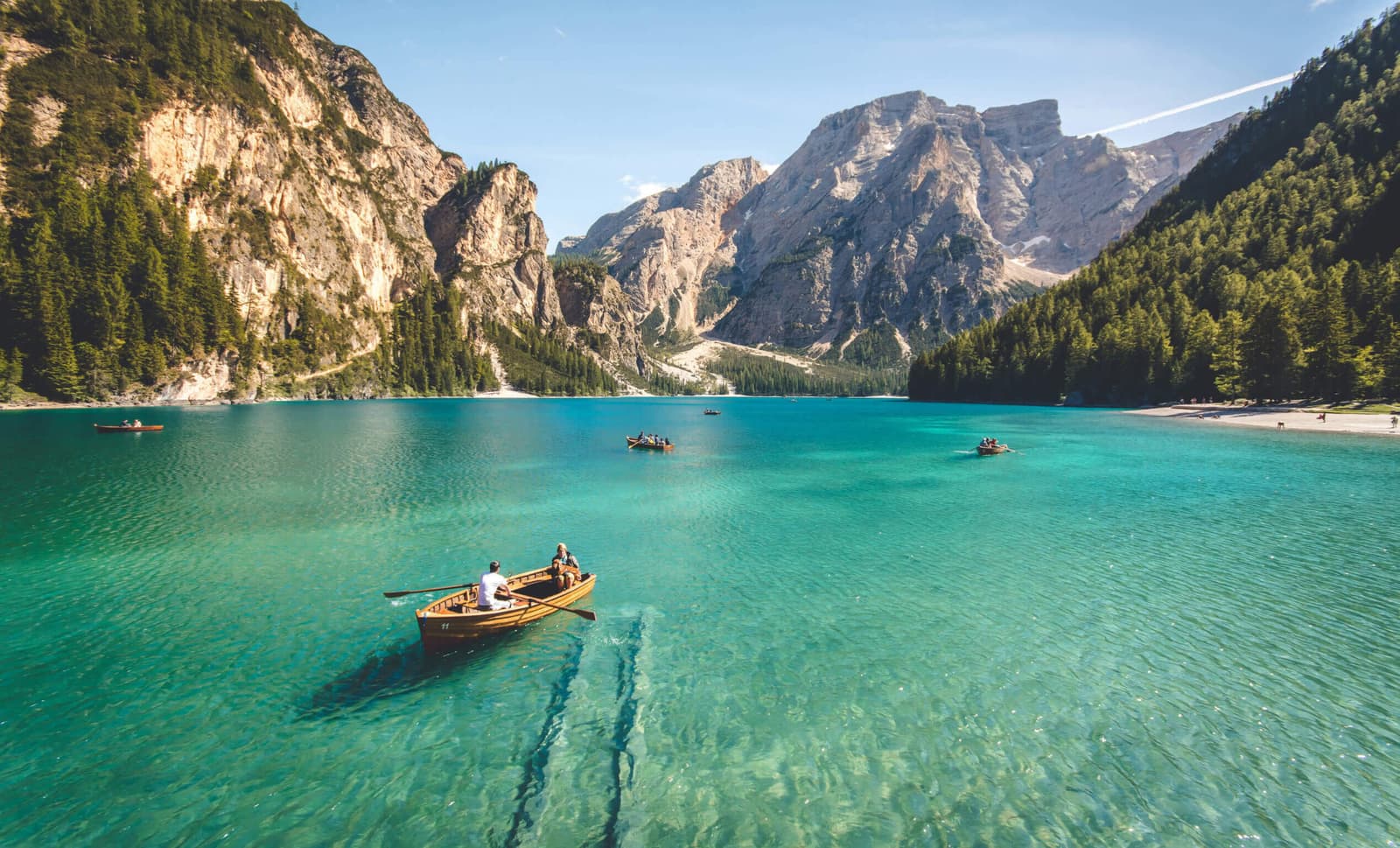 Um pequeno barco em águas calmas com montanhas ao fundo