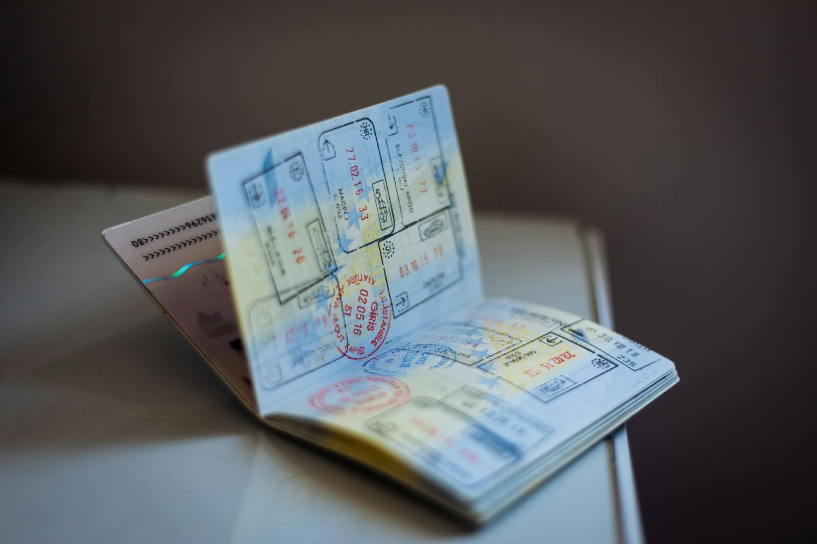 Passaporte aberto sobre uma mesa com vários carimbos